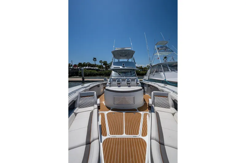  Yacht Photos Pics 2022 Yellowfin 54 Offshore boat with luxurious seating and sleek design, docked under clear blue sky.
