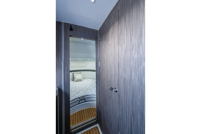  Yacht Photos Pics 2022 Yellowfin 54 Offshore cabin interior with modern wood paneling and cozy bedding.