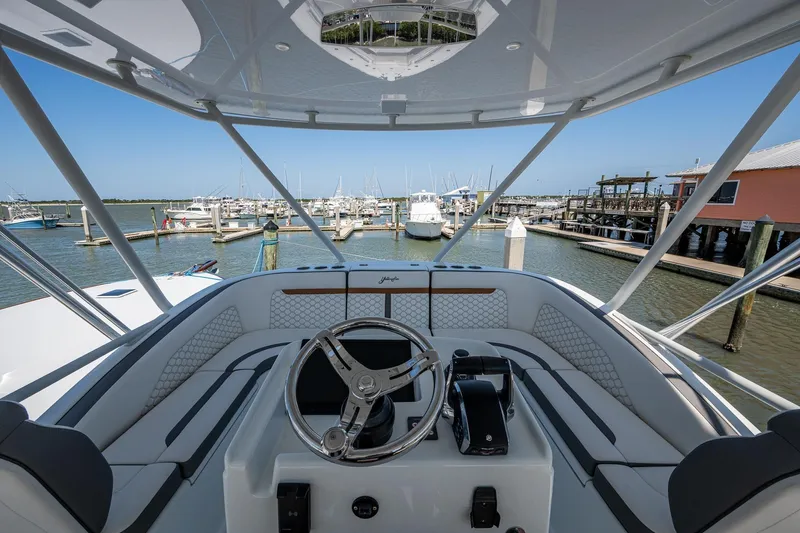  Yacht Photos Pics 2022 Yellowfin 54 Offshore boat helm with marina view, showcasing luxury design and advanced controls.