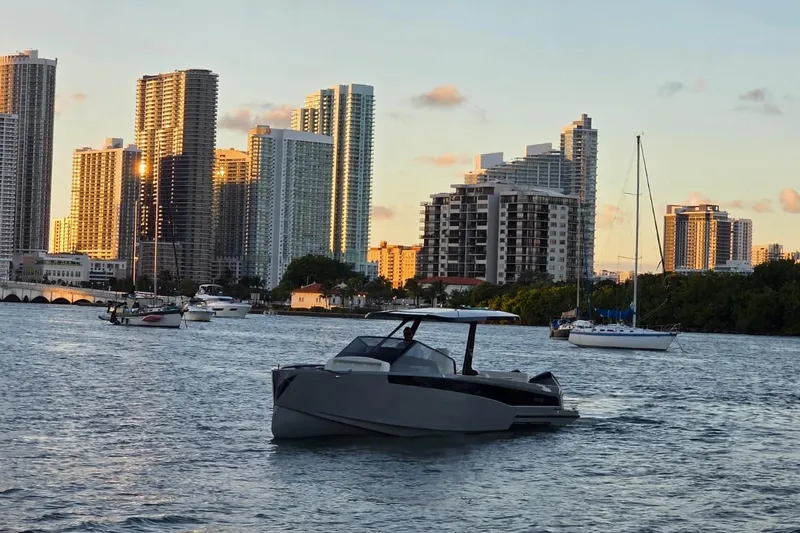 Virtue Yacht Photos Pics Modern Virtue V10 boat on water with city skyline backdrop, 2026 model.