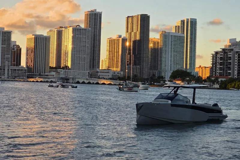 Virtue Yacht Photos Pics Luxury Virtue V10 boat on water with city skyline at sunset, 2026 model.