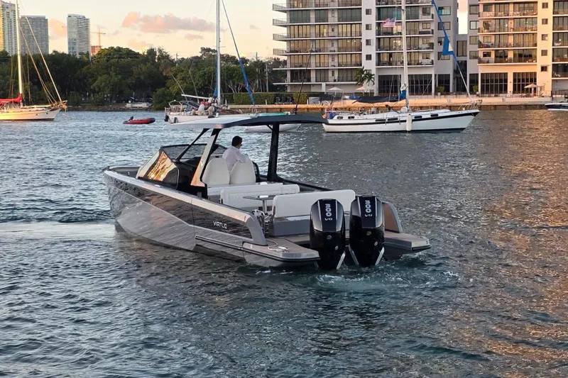 Virtue Yacht Photos Pics 2026 Virtue V10 boat cruising in a marina with cityscape background.
