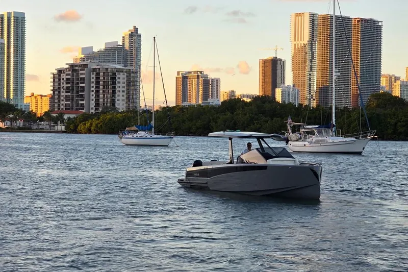 Virtue Yacht Photos Pics Modern Virtue V10 boat cruising near city skyline, 2026 model.