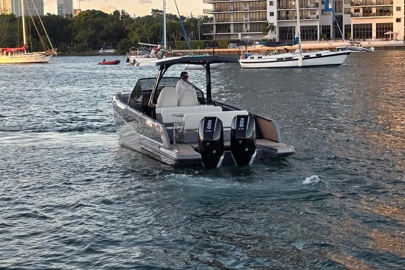 Virtue Yacht Photos Pics 2026 Virtue V10 boat cruising on a scenic waterway with yachts in the background.