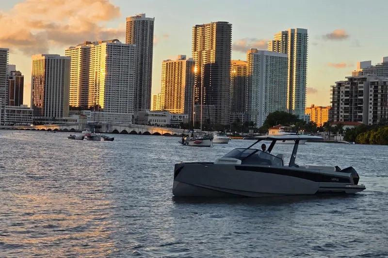 Virtue Yacht Photos Pics Modern Virtue V10 boat on water with city skyline at sunset, 2026 model.