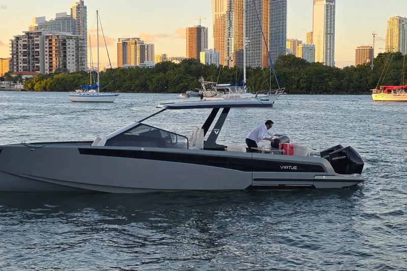 Virtue Yacht Photos Pics Luxury 2026 Virtue V10 boat cruising near city skyline at sunset.