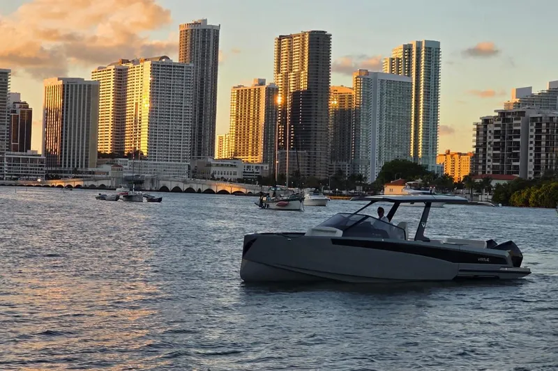 Virtue Yacht Photos Pics Modern Virtue V10 boat on water with city skyline at sunset, 2026 model.