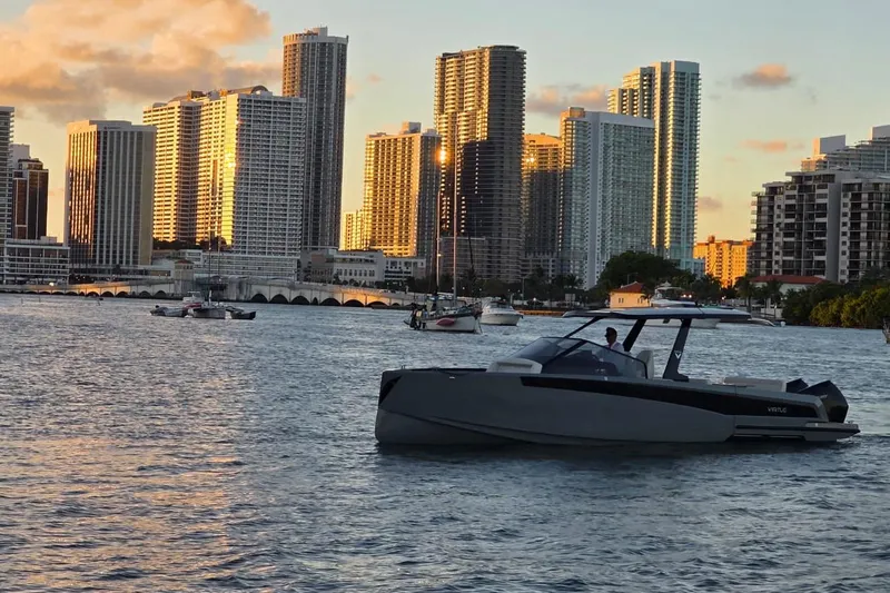 Virtue Yacht Photos Pics Luxury Virtue V10 boat on water with city skyline at sunset, 2026 model.