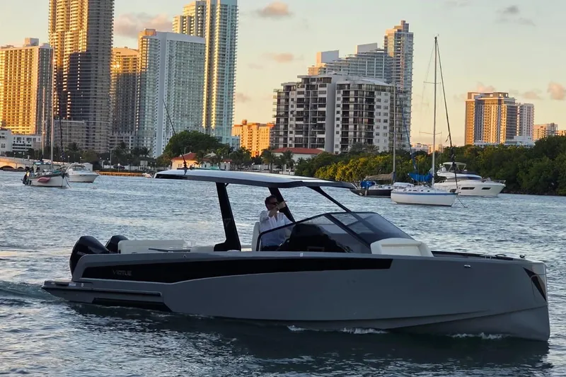 Virtue Yacht Photos Pics Modern 2026 Virtue V10 boat cruising near city skyline at sunset.