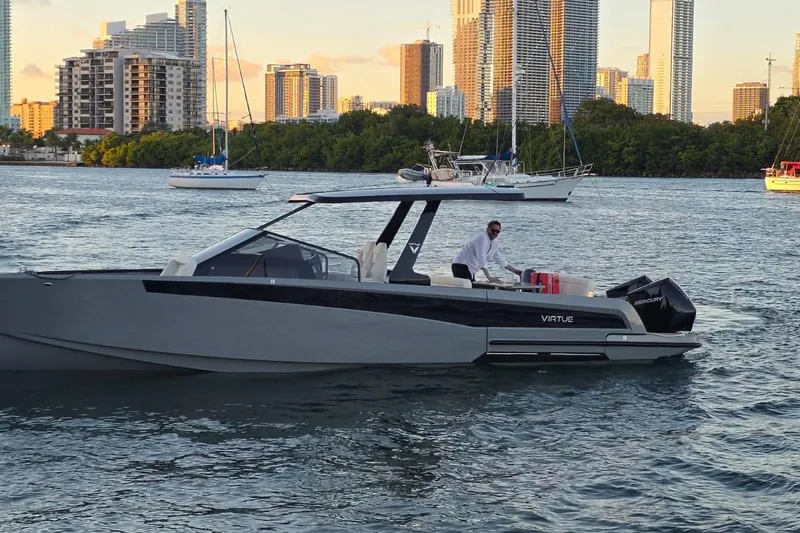 Virtue Yacht Photos Pics 2026 Virtue V10 luxury boat cruising near city skyline at sunset.