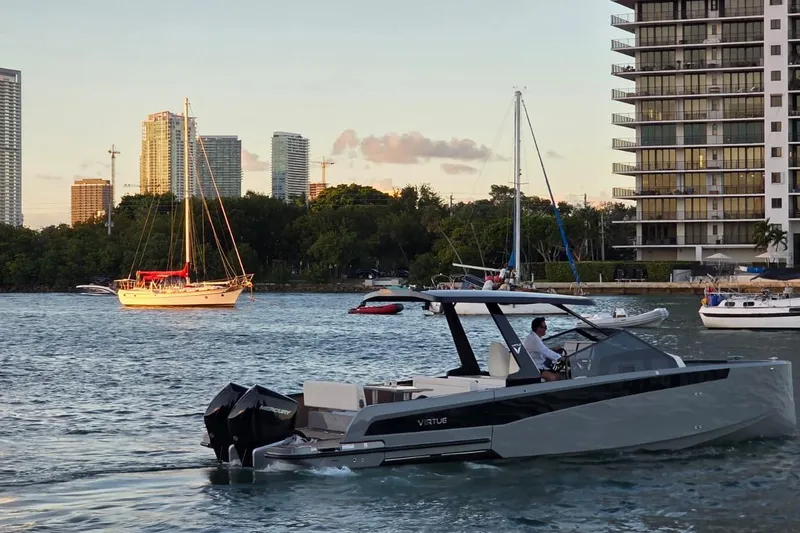 Virtue Yacht Photos Pics 2026 Virtue V10 boat cruising in urban waterfront with city skyline.