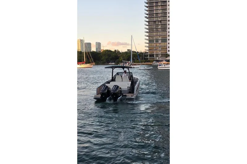 Virtue Yacht Photos Pics A 2026 Virtue V10 boat cruising on a scenic waterfront with city skyline.