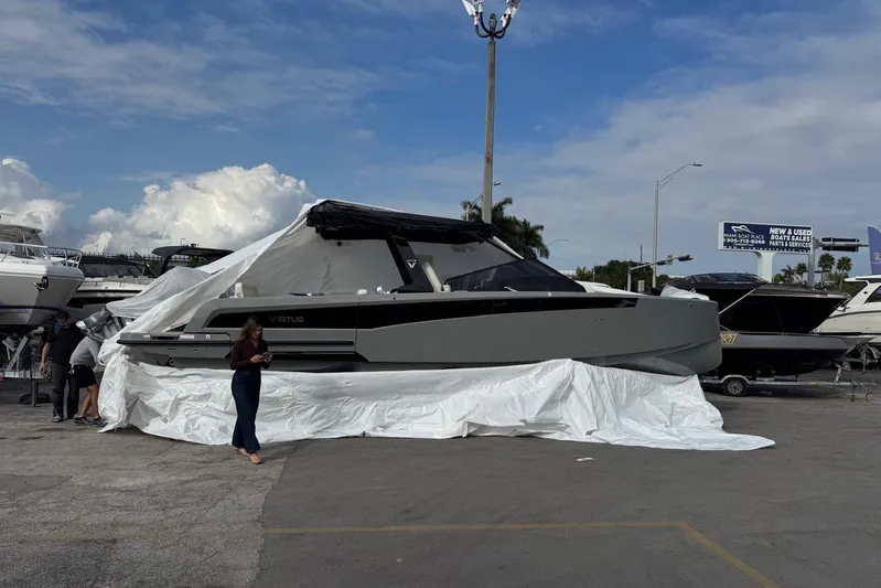 Virtue Yacht Photos Pics 2026 Virtue V10 boat covered with tarp in outdoor display area.
