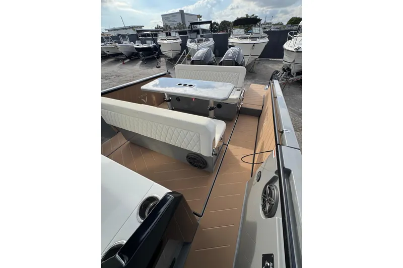 Virtue Yacht Photos Pics 2026 Virtue V10 boat interior with seating and table, docked among other boats.