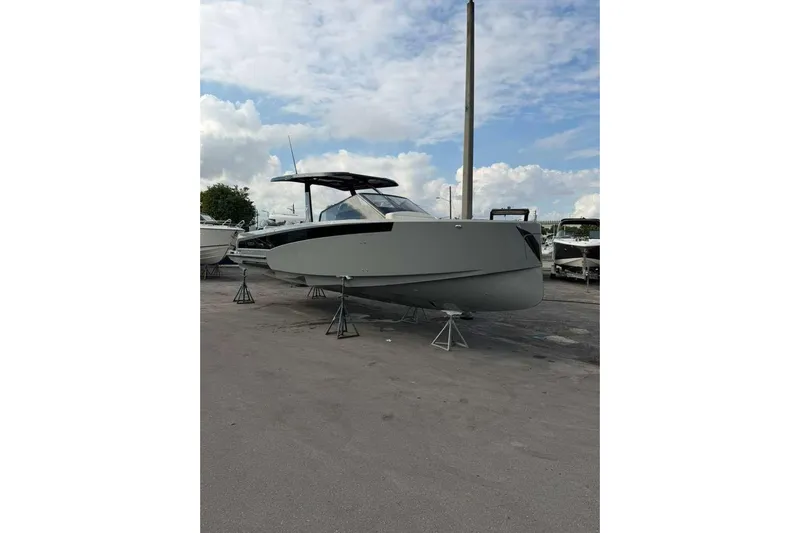 Virtue Yacht Photos Pics 2026 Virtue V10 boat on stands under a partly cloudy sky.