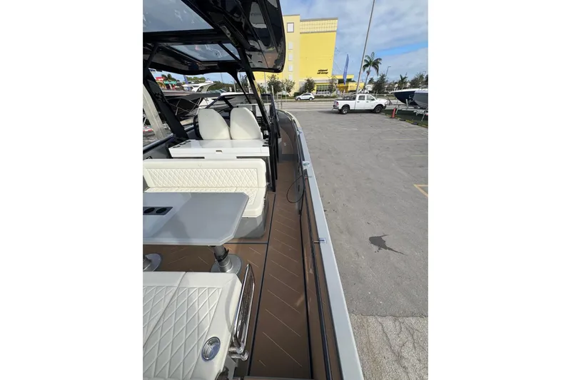 Virtue Yacht Photos Pics 2026 Virtue V10 boat interior with white seating and table, parked outdoors.