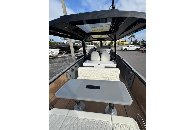 Virtue Yacht Photos Pics 2026 Virtue V10 boat interior with modern seating and table, docked outdoors.