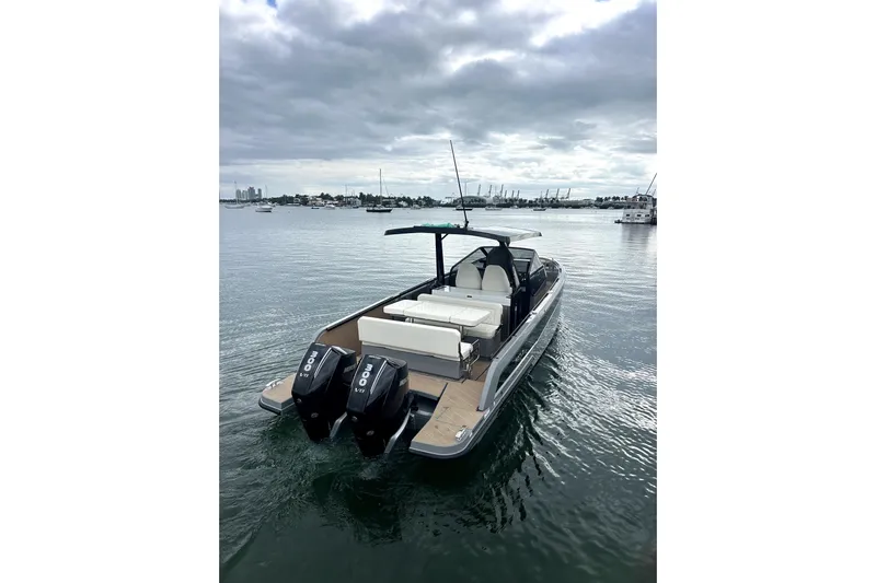 Virtue Yacht Photos Pics 2026 Virtue V10 boat with dual engines on calm water under cloudy sky.