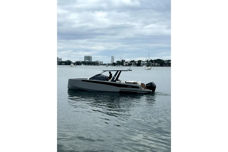 Virtue Yacht Photos Pics 2026 Virtue V10 boat cruising on a calm lake under a cloudy sky.