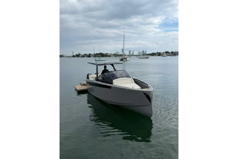 Virtue Yacht Photos Pics 2026 Virtue V10 boat on calm water with city skyline in background.