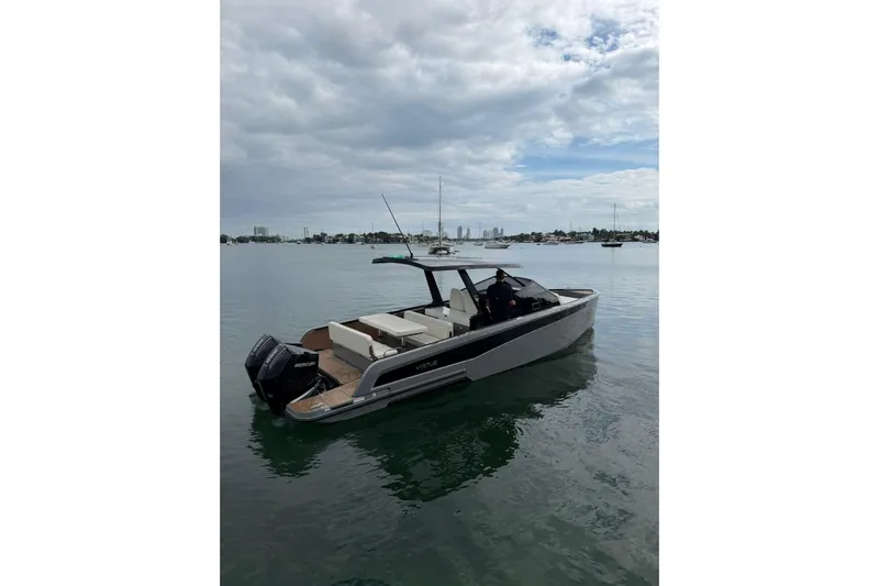 Virtue Yacht Photos Pics 2026 Virtue V10 boat on calm water under cloudy sky.