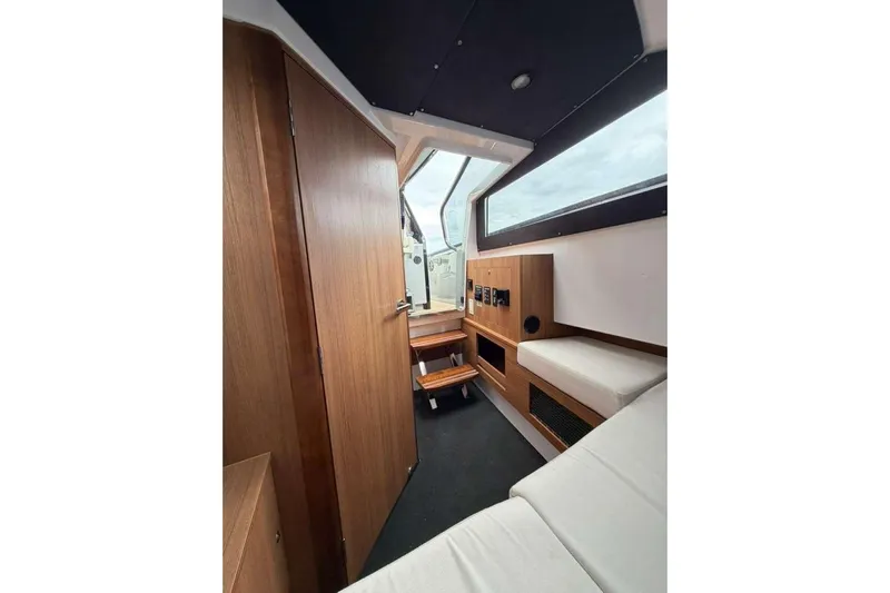 Virtue Yacht Photos Pics Interior of 2026 Virtue V10 boat with wooden accents and seating area.