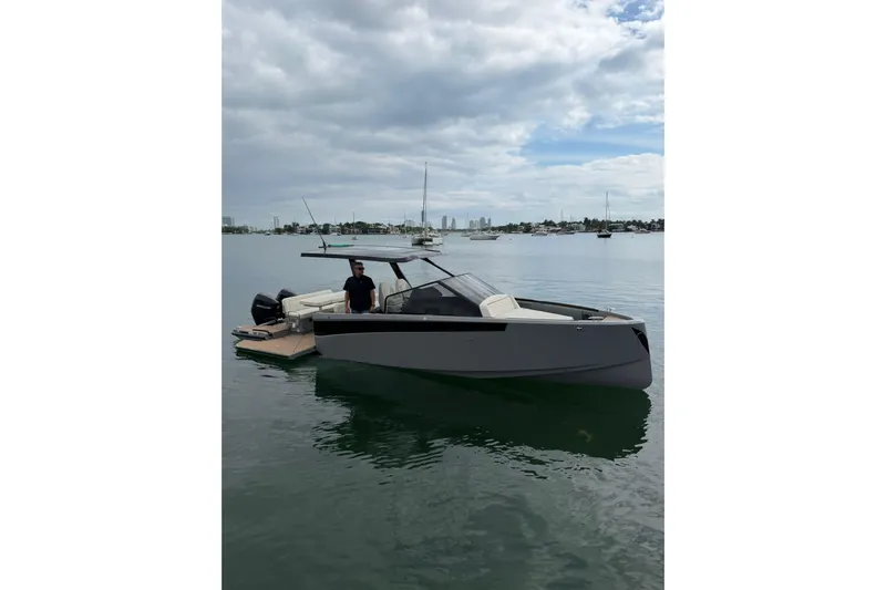 Virtue Yacht Photos Pics 2026 Virtue V10 boat on calm water with cloudy sky backdrop.