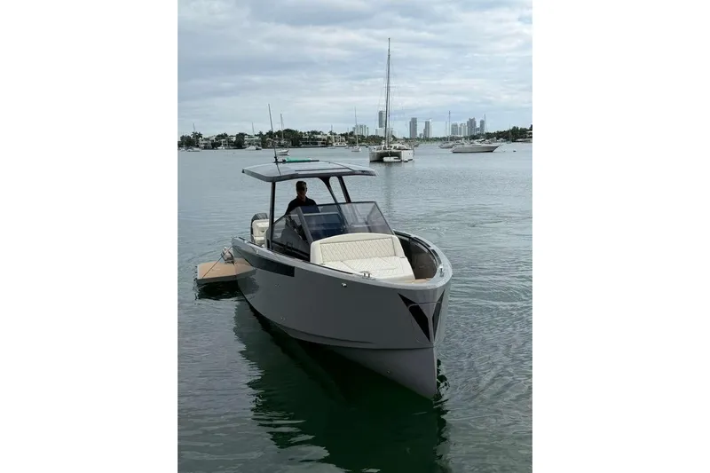 Virtue Yacht Photos Pics 2026 Virtue V10 boat on calm water with city skyline in background.