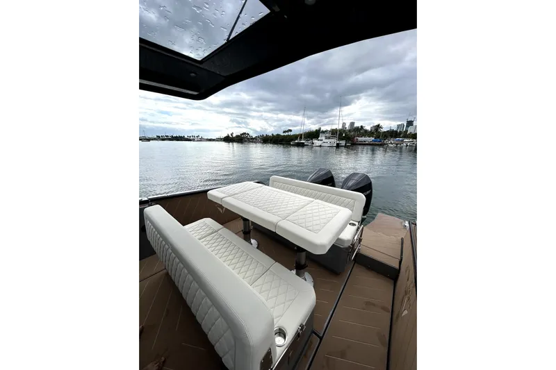 Virtue Yacht Photos Pics Luxurious 2026 Virtue V10 boat interior with white quilted seating, overlooking a serene marina.