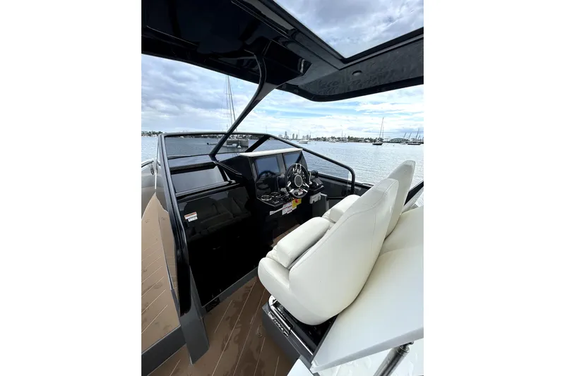 Virtue Yacht Photos Pics Interior view of 2026 Virtue V10 boat cockpit with white seating and steering wheel.