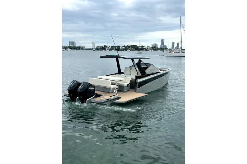 Virtue Yacht Photos Pics Modern 2026 Virtue V10 boat cruising on calm waters with city skyline backdrop.