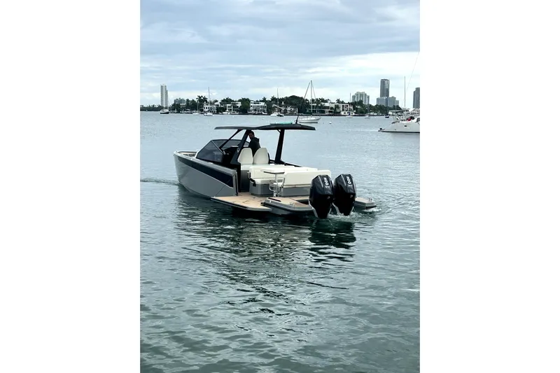 Virtue Yacht Photos Pics 2026 Virtue V10 boat on calm water with city skyline in background.