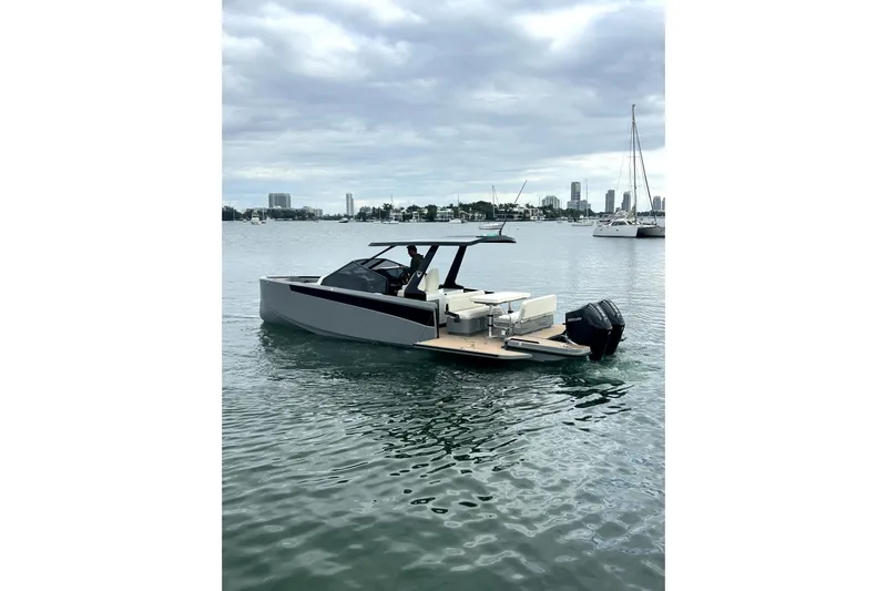 Virtue Yacht Photos Pics 2026 Virtue V10 boat on calm water with city skyline in background.