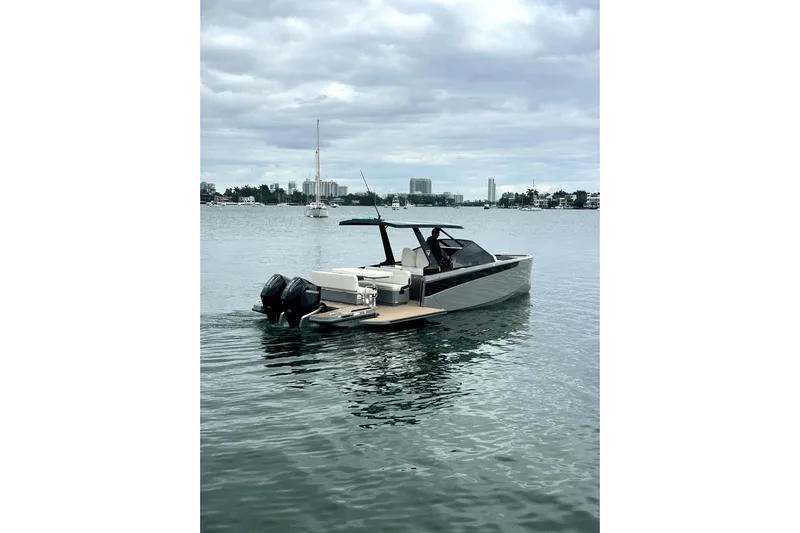 Virtue Yacht Photos Pics 2026 Virtue V10 boat on calm water with city skyline in background.
