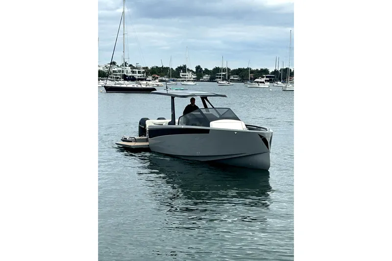 Virtue Yacht Photos Pics Modern 2026 Virtue V10 boat cruising in a marina with sailboats in the background.
