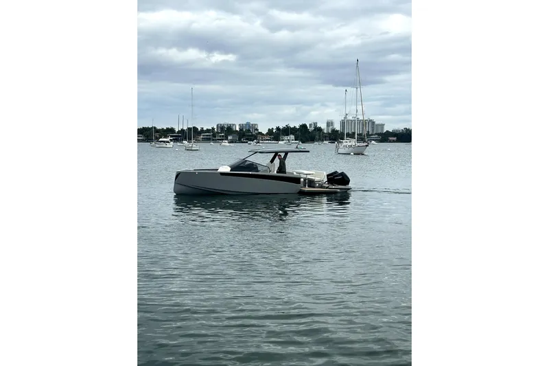 Virtue Yacht Photos Pics Modern 2026 Virtue V10 boat on calm waters with cityscape background.