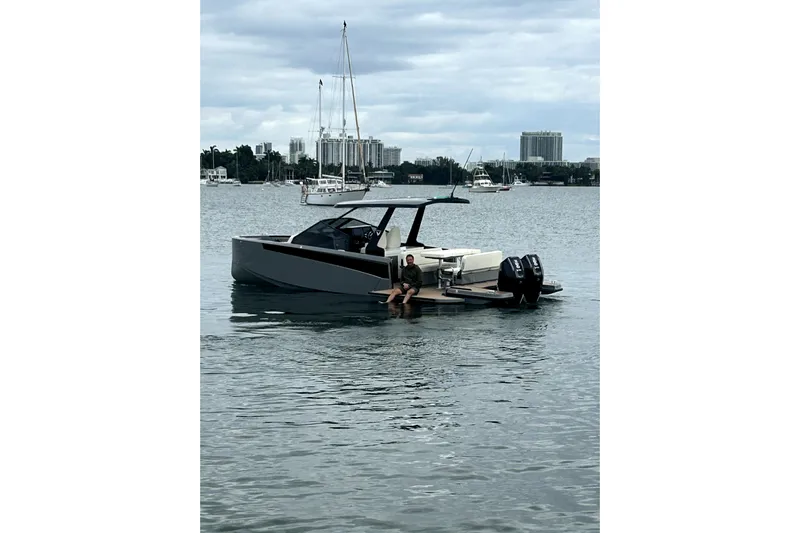 Virtue Yacht Photos Pics Modern 2026 Virtue V10 boat on calm water with cityscape background.