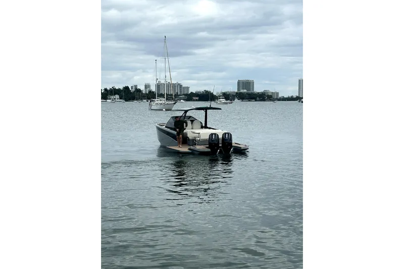 Virtue Yacht Photos Pics Luxury Virtue V10 boat on calm waters, 2026 model, with city skyline backdrop.
