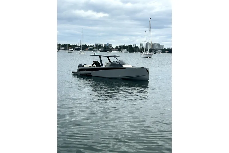 Virtue Yacht Photos Pics 2026 Virtue V10 boat on calm water with cityscape background.