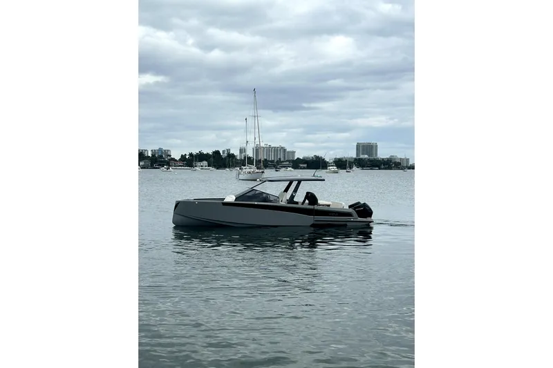 Virtue Yacht Photos Pics 2026 Virtue V10 boat on calm water with city skyline in background.
