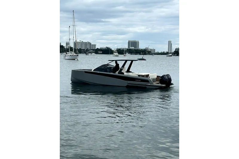 Virtue Yacht Photos Pics 2026 Virtue V10 boat on calm water with city skyline in background.