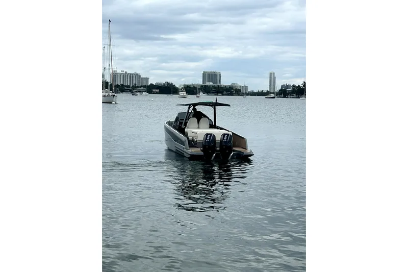 Virtue Yacht Photos Pics A 2026 Virtue V10 boat on a calm waterway with cityscape background.