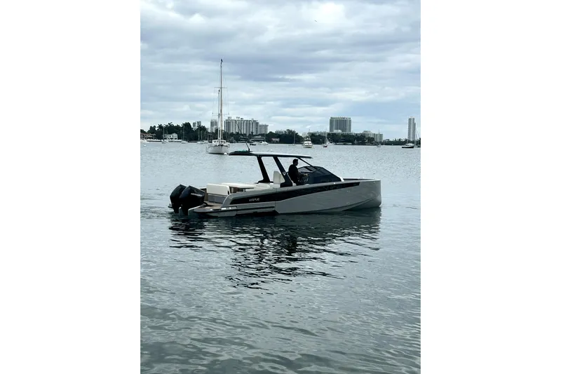 Virtue Yacht Photos Pics 2026 Virtue V10 boat on calm water with city skyline background.