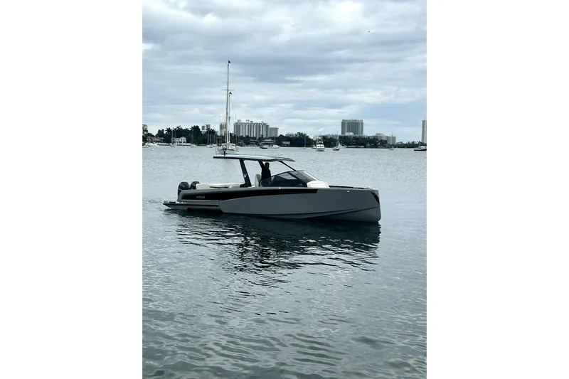 Virtue Yacht Photos Pics 2026 Virtue V10 boat on calm water with city skyline background.