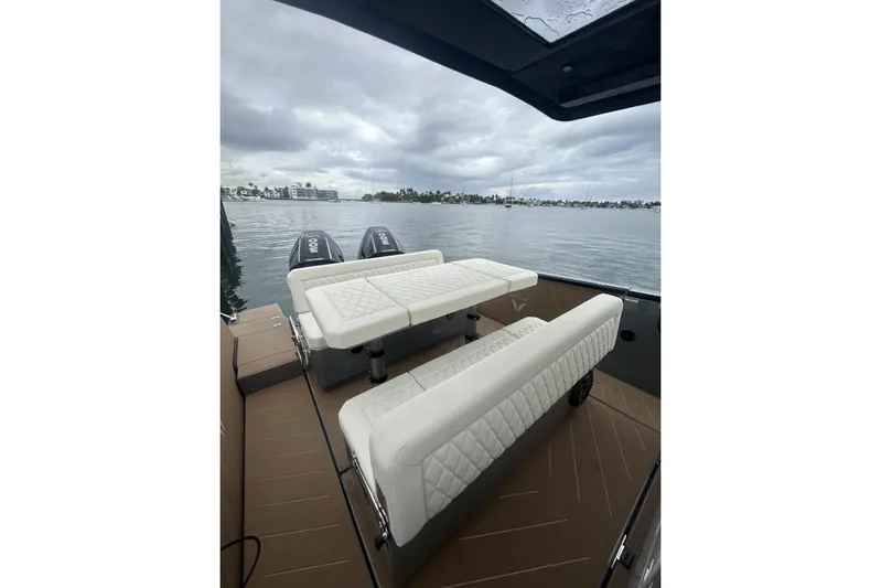 Virtue Yacht Photos Pics Luxury Virtue V10 boat interior with white seating, overlooking a calm waterfront.