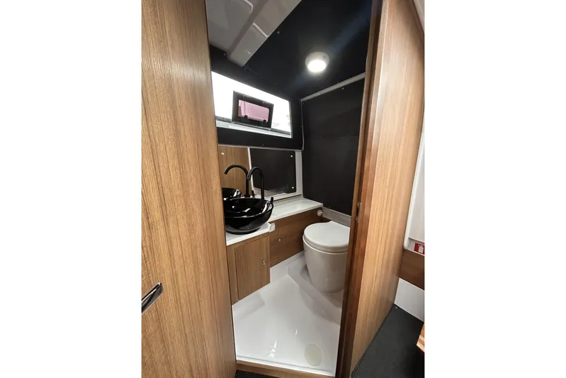 Virtue Yacht Photos Pics 2026 Virtue V10 bathroom interior with modern fixtures and wooden cabinetry.