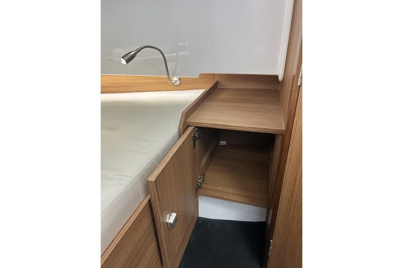 Virtue Yacht Photos Pics 2026 Virtue V10 interior with wooden cabinet and reading light.