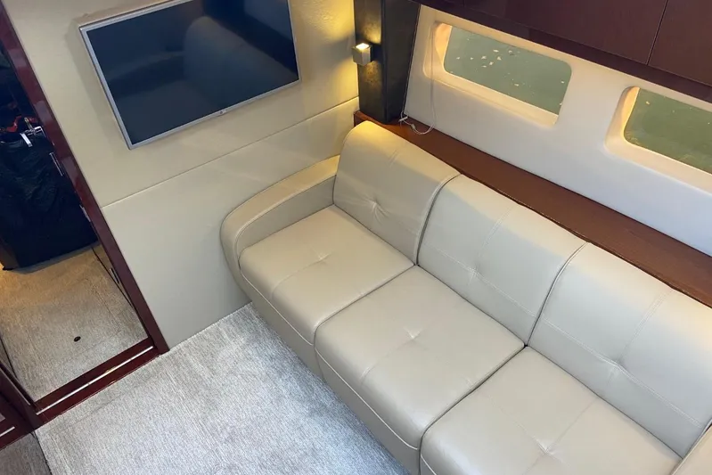 Godsend Yacht Photos Pics Interior of 2015 Sea Ray 470 Sundancer with beige sofa and wall-mounted TV.
