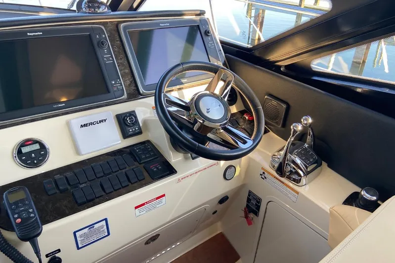 Godsend Yacht Photos Pics Control panel of a 2015 Sea Ray 470 Sundancer yacht with steering wheel and navigation screens.