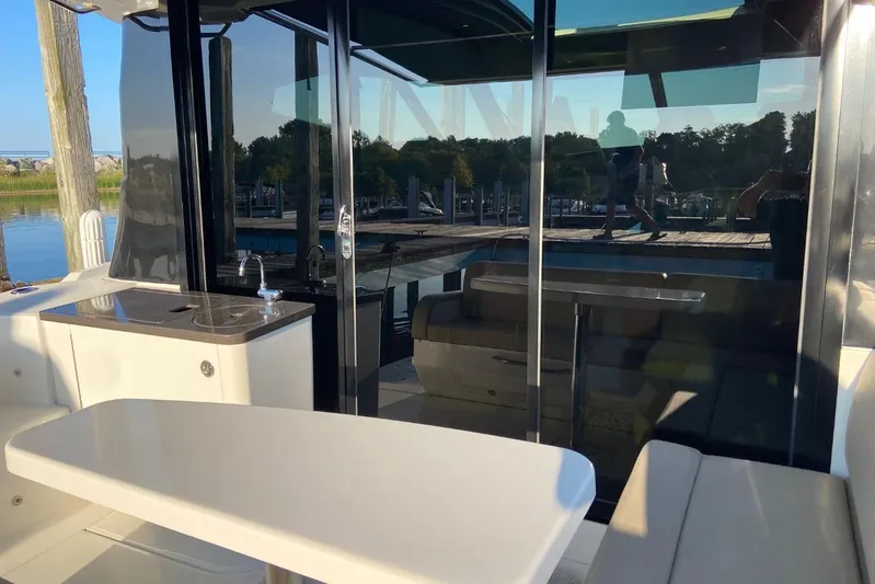 Godsend Yacht Photos Pics 2015 Sea Ray 470 Sundancer yacht interior with seating and kitchenette, docked by the water.